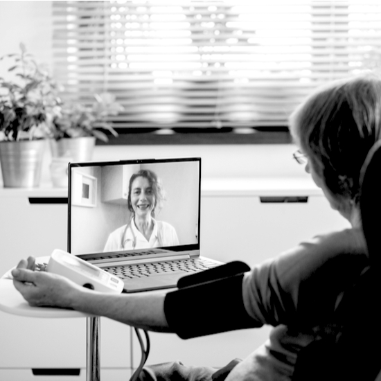 consulta_online Mujer que está teniendo una teleconsulta, en la imagen aparece tomándose la tensión y hablando con la doctora a través del ordenador